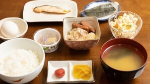 Una mesa con diversos alimentos, como arroz, pescado, huevo y sopa.