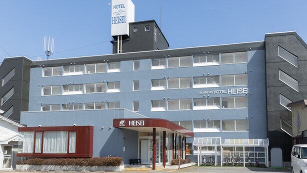 Un hotel de varios pisos con un letrero llamativo del Hotel Heisei.