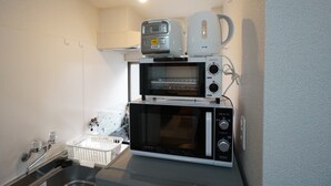 A kitchenette with a microwave, toaster, and kettle stacked on top of each other. - Apartment Camon EBR0001E (Osaka)