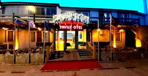 A hotel entrance with a red carpet, steps leading up to the door, and a sign that reads "YAVUZ HOTEL". - Akcay Yavuz Otel (Edremit)