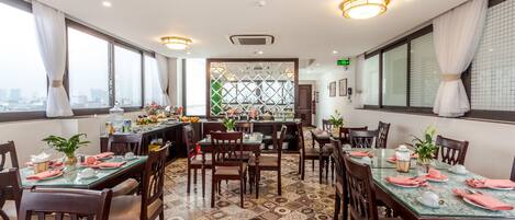 Un comedor con varias mesas, sillas y un separador decorativo.
