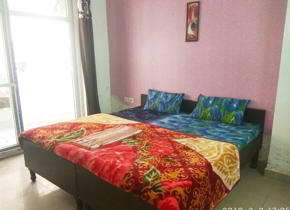 Ein Schlafzimmer mit Bett, Fenster und einer Wand mit einem Gemälde.