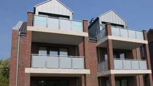A multi-story building with a brick facade, balconies, and large windows.