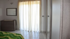 A bedroom with a bed, a dresser, a wardrobe, and a window with curtains. - SU CUILE-relax house suitable for families or groups of friends IUN P8183 (Sassari)