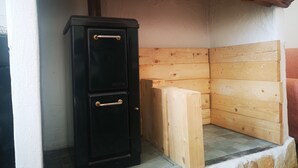 Une pièce de taille modeste, avec un meuble noir, des murs recouverts de panneaux en bois et une base en pierre.