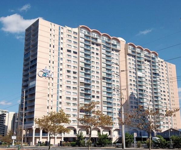 Un hôtel de grande hauteur doté de nombreux balcons, d’une enseigne bien visible et surplombant un ciel dégagé.