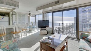 Ein geräumiger Balkon mit Fernseher, Essbereich und Sitzgelegenheiten.