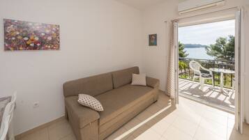 Apartamento, vista para o mar | Área de estar | TV de tela plana