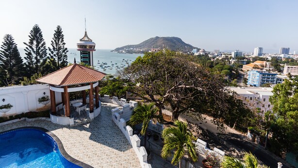 A rooftop pool area with a gazebo, a view of the sea, and surrounding buildings. - Marina Luxury Vung Tau (Ho Chi Minh City)