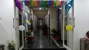 A hotel corridor with glass doors, potted plants, and colorful decorations. - Hotel PP Palace (Puri)