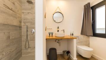 A modern bathroom with a shower, toilet, and sink.
