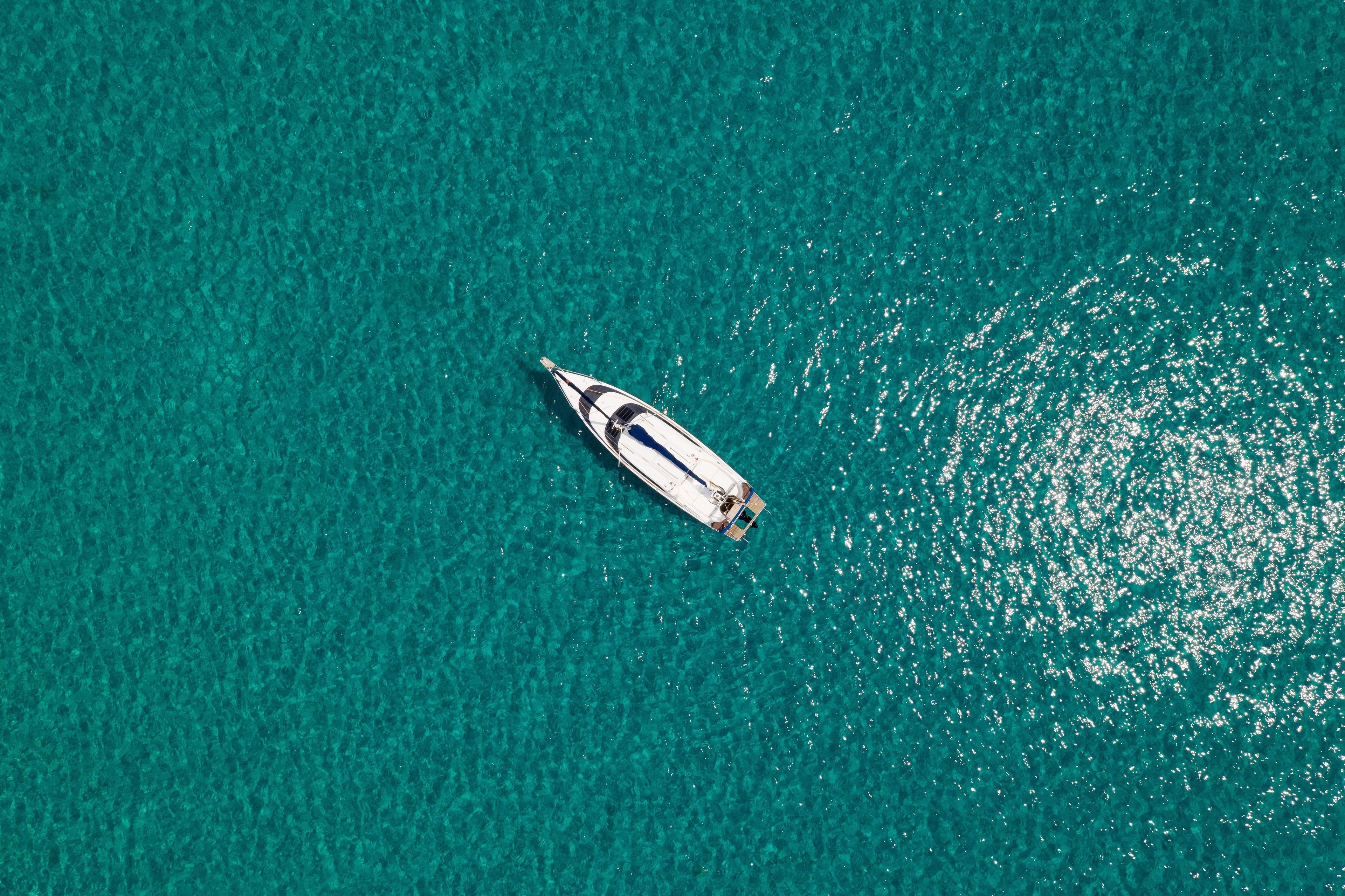 An aerial view of a boat on clear turquoise water.