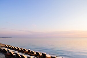 En la playa, sillas reclinables de playa, sombrillas, toallas de playa