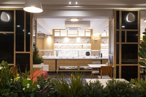 A modern kitchen with a marble backsplash, wooden cabinets, and a central island.