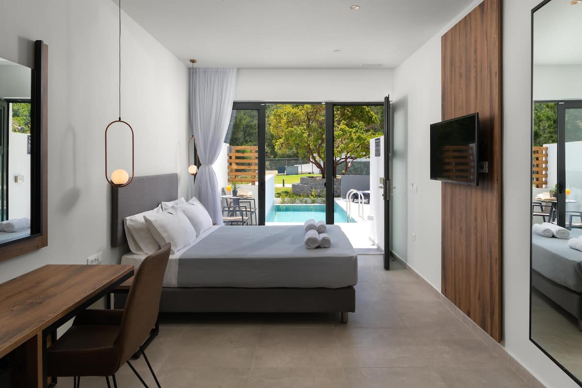 Une chambre à coucher moderne avec un lit, un bureau et un téléviseur.