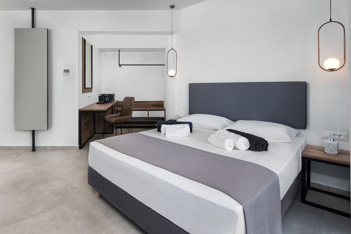 Une chambre d’hôtel moderne avec un grand lit, un bureau et une chaise.