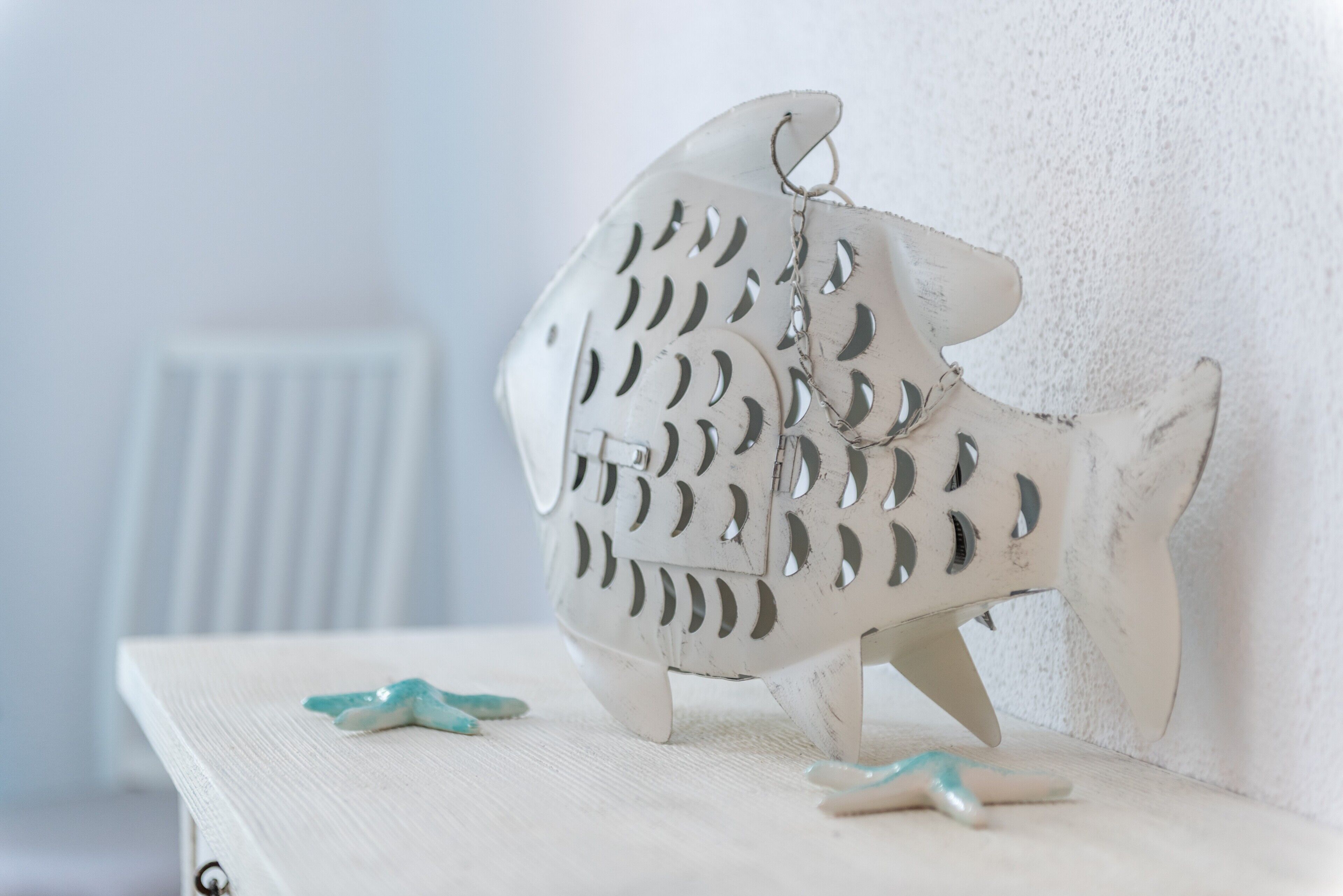 A decorative fish-shaped object with a keychain on a white surface.