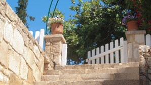 A stone staircase with a white picket fence at the top, leading to a white building.