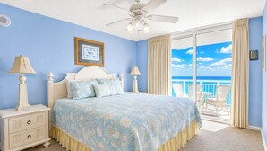 A bedroom with a bed, nightstands, a ceiling fan, a framed picture, and a balcony with a view. - Crescent Shores S 1309 - Oceanfront Luxury & Unmatched Views! (North Myrtle Beach)