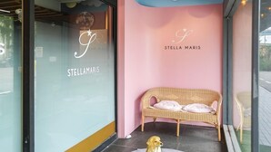 Een gezellig interieur met een rieten bank, een klein beeldje van een hond, en de naam 'STELLAMARIS' op de muur.