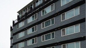 Een meerlaags hotel met een moderne gevel, grote ramen en een bord waarop 'Stellaris Hotel' staat.