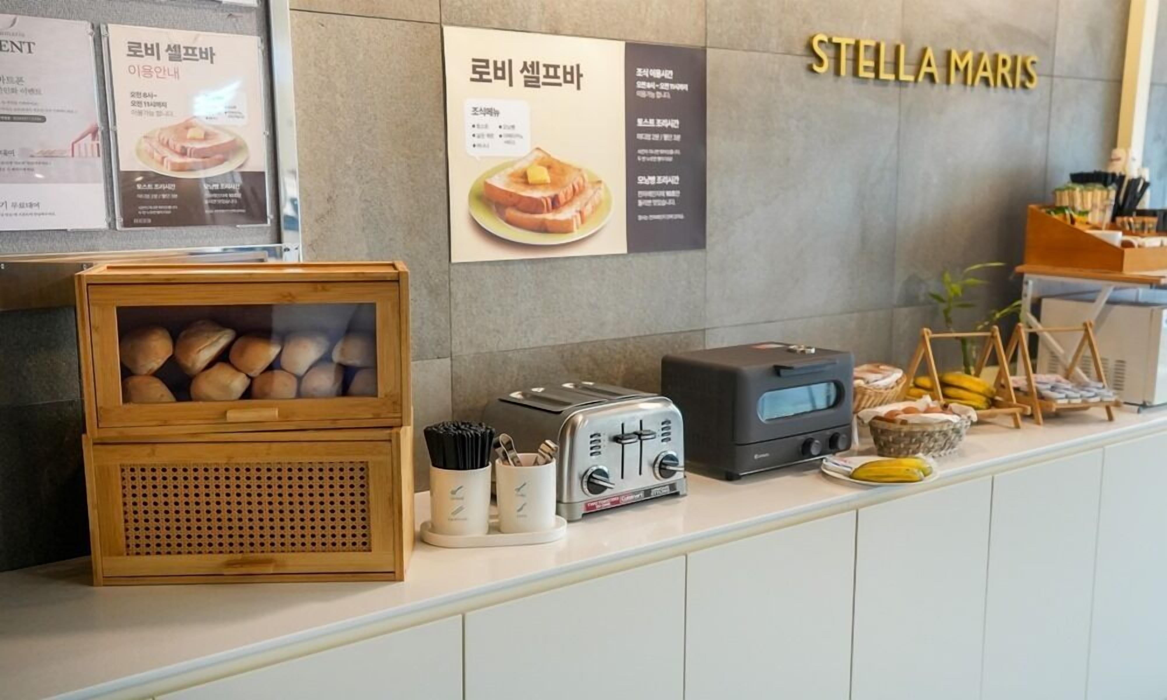 Un comptoir pour le petit-déjeuner avec du pain, un grille-pain et un tableau affichant le menu.