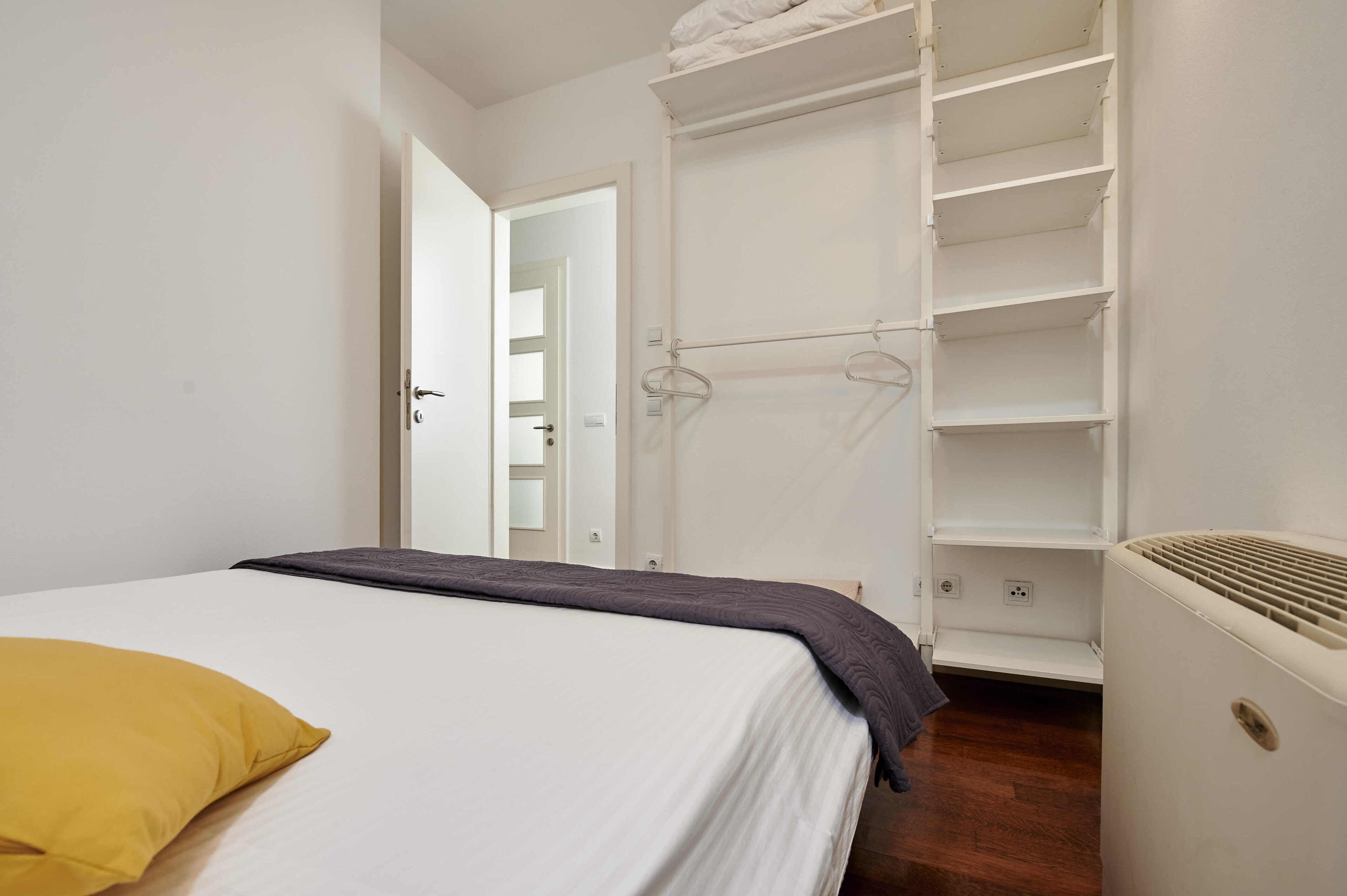 A bedroom with a bed, a wardrobe, and a radiator.
