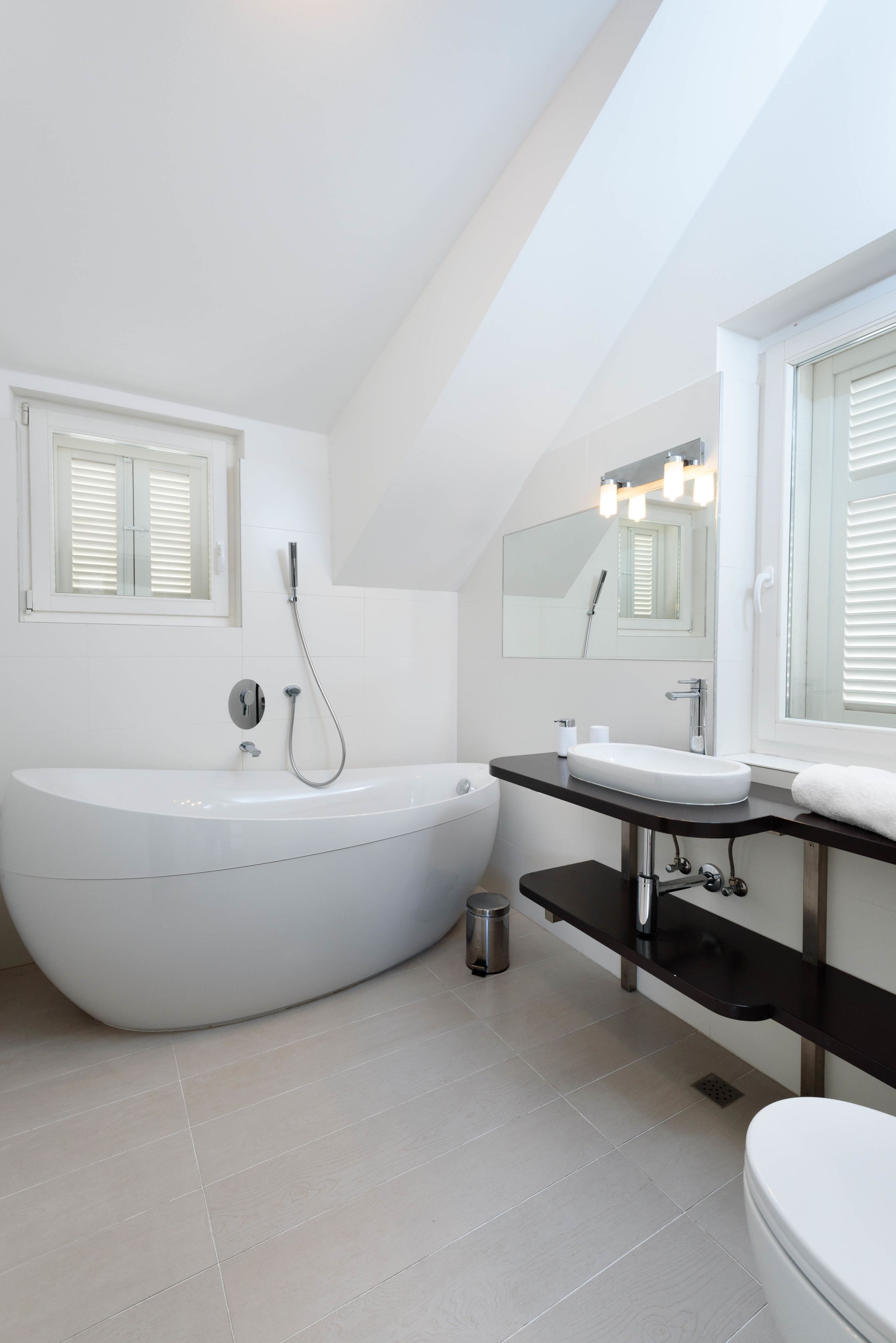 A modern bathroom with a freestanding bathtub, a sink, and a toilet.