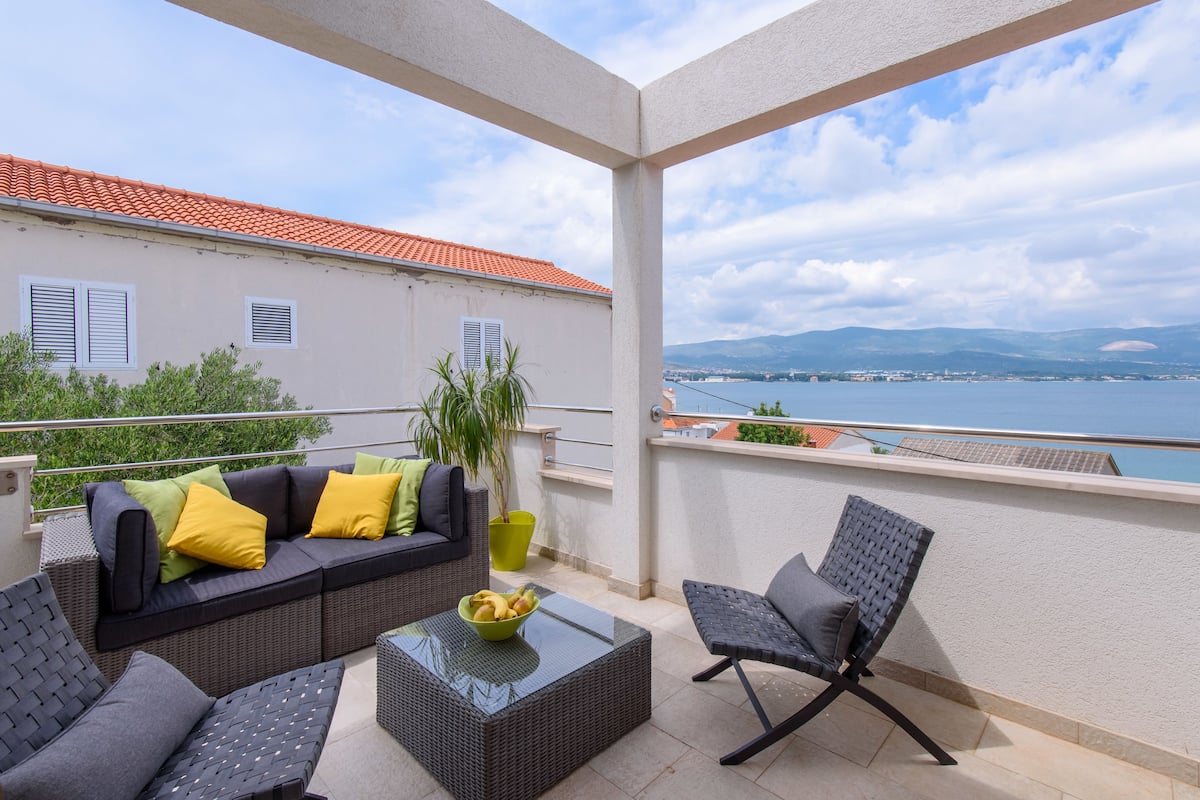 Un balcon avec un canapé, des chaises et une table.