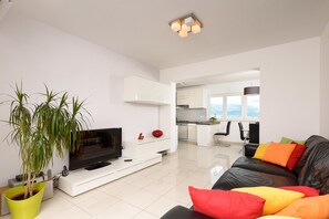 Attico, terrazzo, vista mare | Area soggiorno | TV a schermo piatto