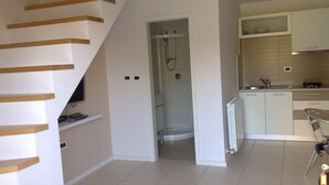 A modern kitchen with white cabinets, a built-in oven, and a small island. - Villa Brumnic Apartments (Moscenicka Draga)