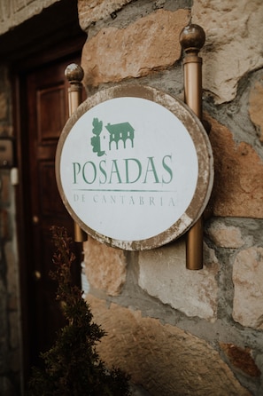 A sign with the text "POSADAS DE CANTABRIA" mounted on a stone wall. - Posada Somavilla (Ribamontan al Mar)