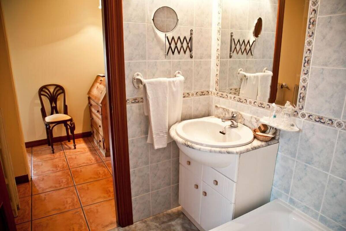 A bathroom with a white sink, mirror, and towel rack.