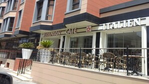 A reception cafe with a sign that reads "RECEPTION CAFE" and "ITALIEN" on the building facade.