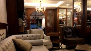 Een gezellige woonkamer met een beige bank, een bruine fauteuil en een houten salontafel.