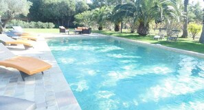 Una piscina al aire libre de temporada, sombrillas