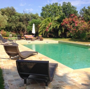 Piscina com espreguiçadeiras e área de terraço.