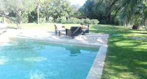 Una piscina al aire libre de temporada, sombrillas