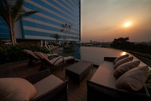 Una piscina al aire libre, sillones reclinables de piscina