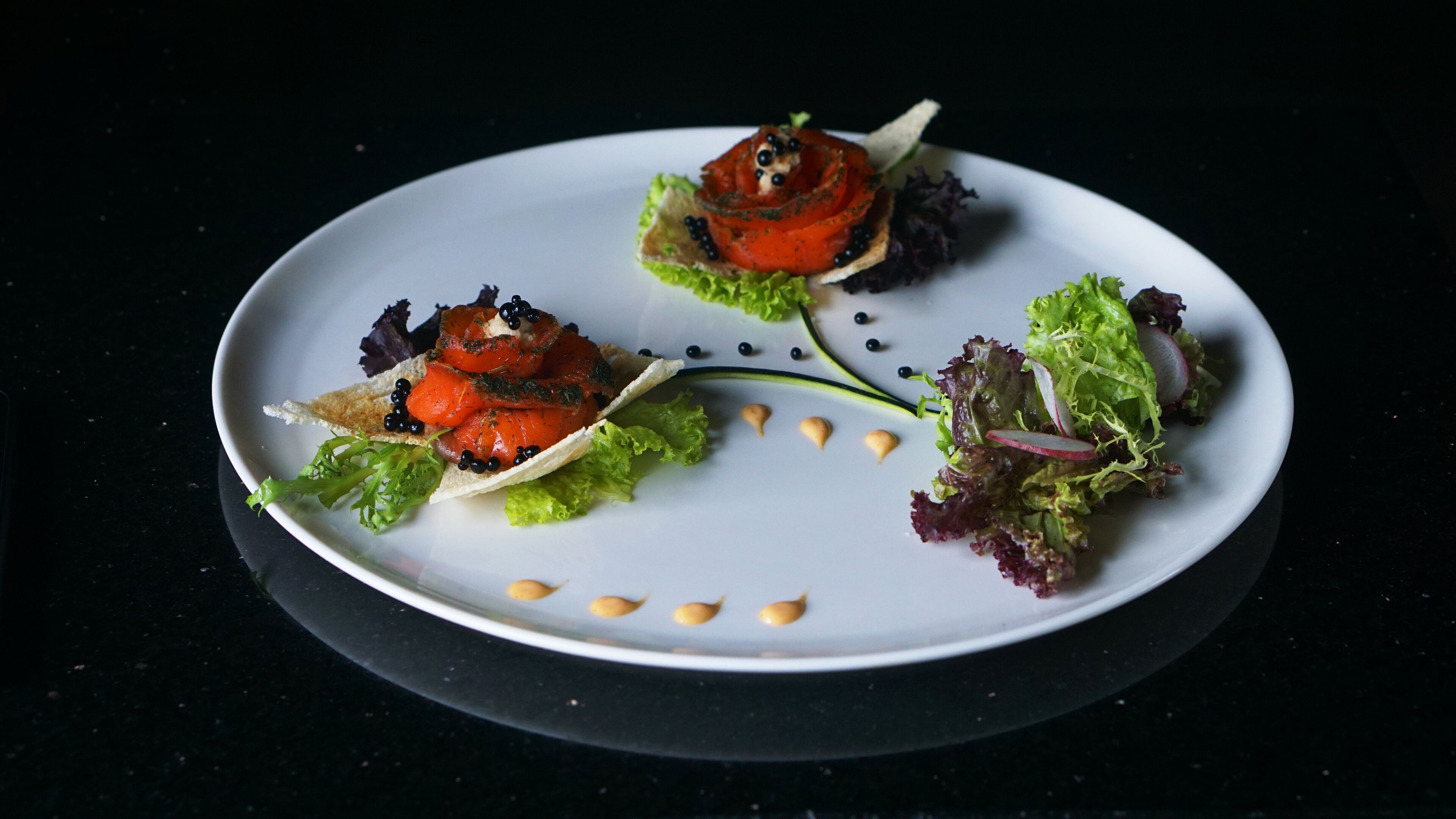 A white plate with three different food items, each with a unique presentation.