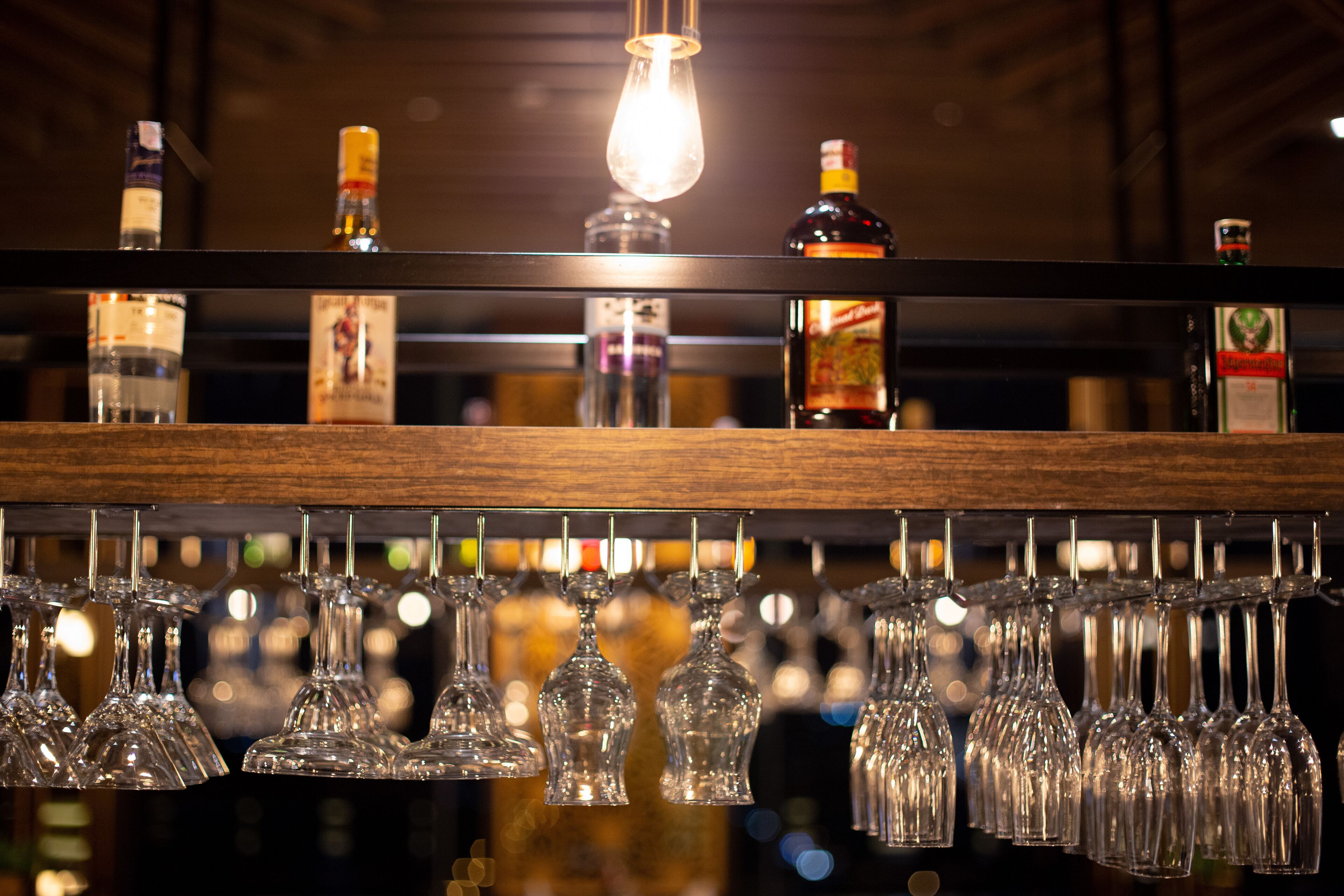 A bar area with bottles and glasses on shelves.