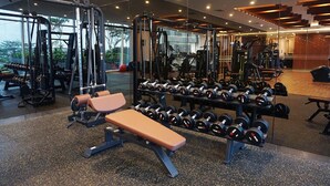 Een moderne sportschool met diverse gewichthefapparaten, banken en haltersets.