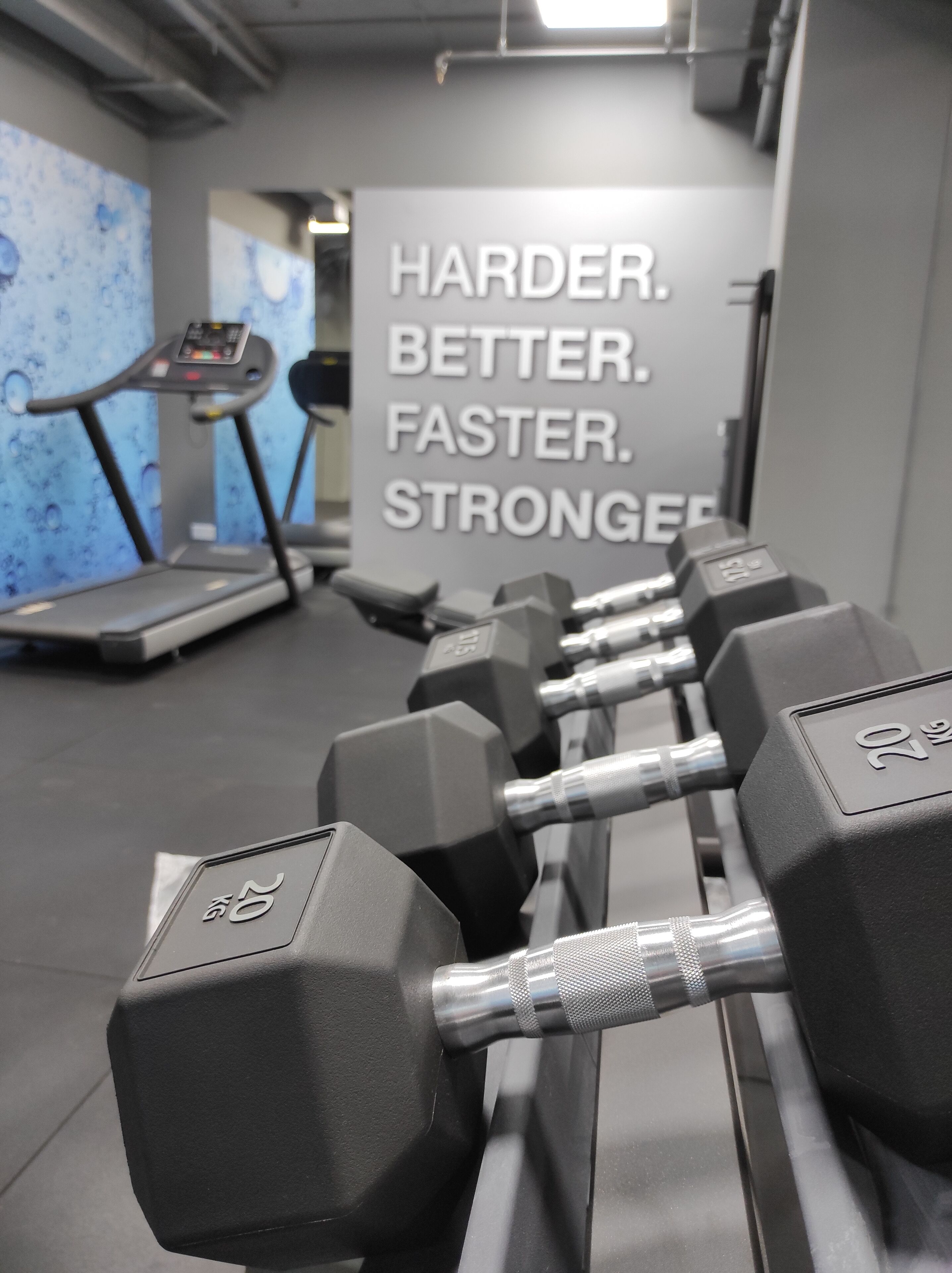 Ett gym med träningsutrustning och inspirerande texter på väggarna.