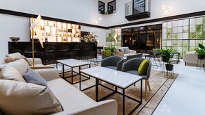 Un salón amplio y bien iluminado con arreglos de asientos, un bar con estantes llenos de botellas y grandes ventanales que ofrecen vistas al exterior.
