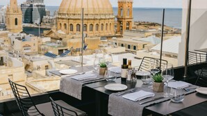 Mesa para dos personas dispuesta con vista a la ciudad, incluyendo una cúpula destacada y edificios al fondo.