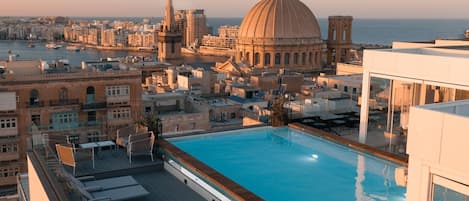 Una piscina al aire libre, tumbonas