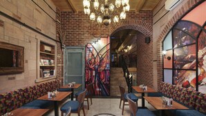 Un restaurante con paredes de ladrillo, mesas de madera y asientos acolchados azules.