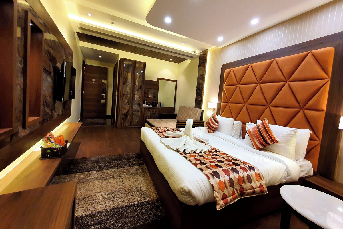 Una habitación de hotel con una cama grande, zona de estar y baño.