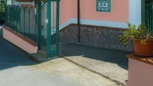 A two-story building with a pink facade, a visible balcony, and a sign on the wall. - Il Tintore (Tramonti)