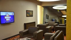 A hotel lobby with leather seating, a television displaying 'INDIRIMIN KRAI', and artwork on the walls. - Admiral Hotel (Kocasinan)
